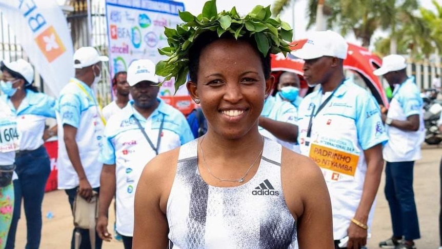 Kenyan-born Bahraini athlete Damaris Muthee Mutua smiles for the camera while wearing a crown of leaves.
