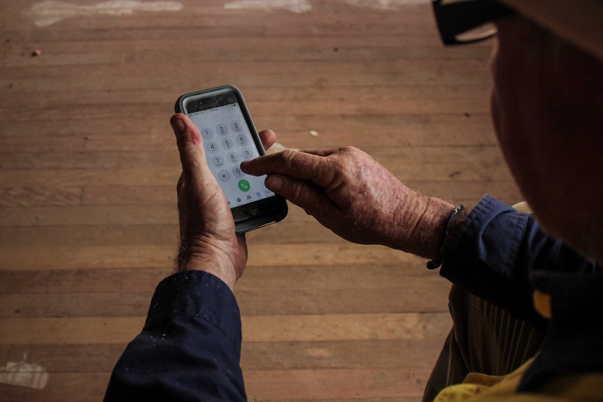 Russell Young typing on his mobile phone