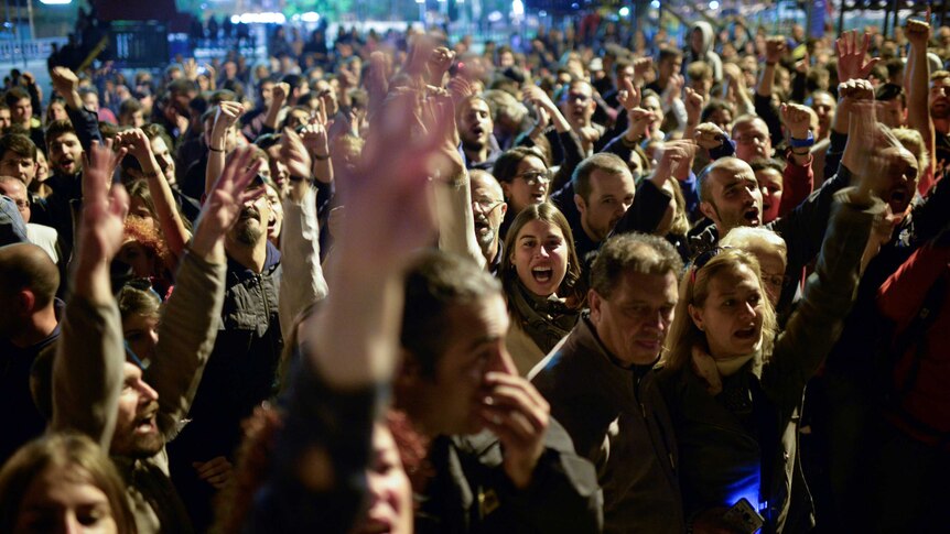 People celebrate outside a polling station after polls closed at 5:00am AEDT. (Reuters/Vincent West)