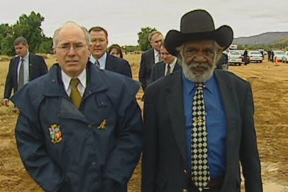 Max Stuart walks in the rain with former prime minister John Howard