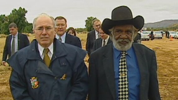 Max Stuart walks in the rain with former prime minister John Howard
