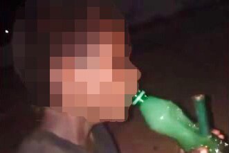 Young boy smoking a bong in the Kimberley, face unrecognizable 