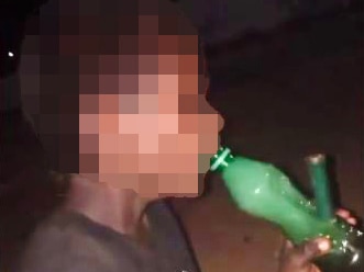 Young boy smoking a bong in the Kimberley, face unrecognisable.