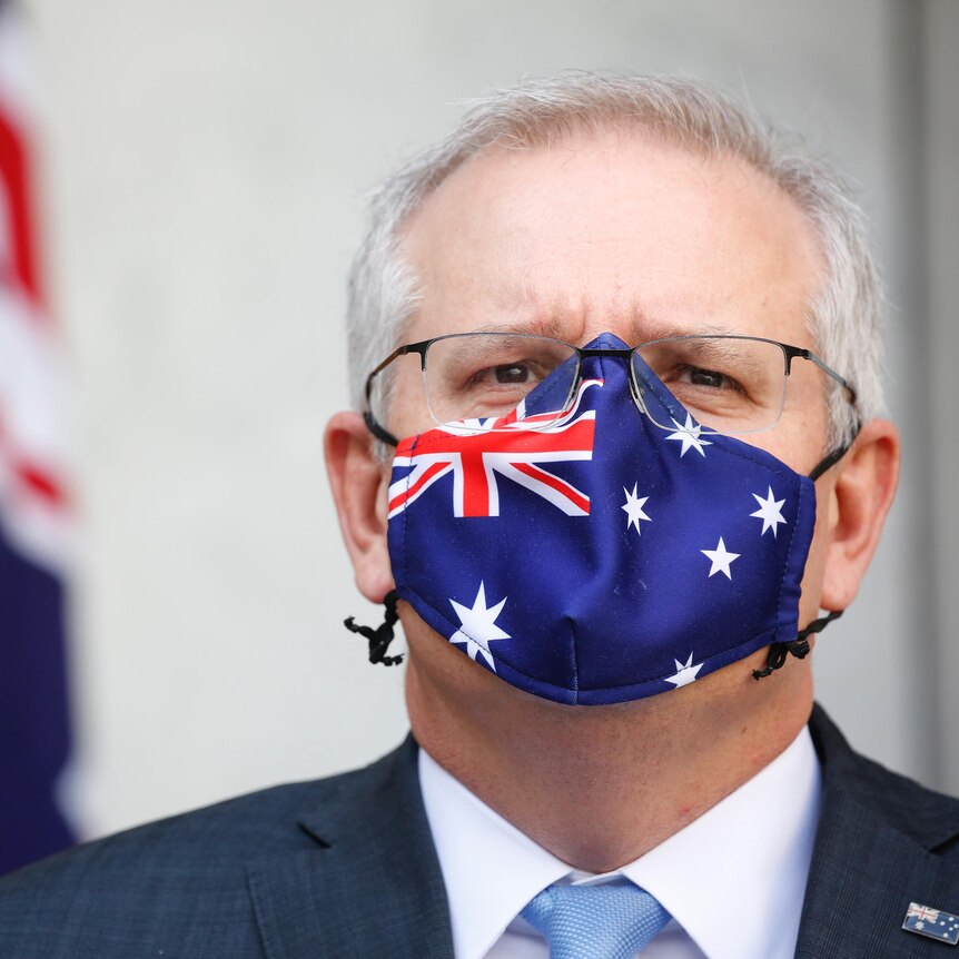 Tight shot of Morrison is staring straight ahead wearing a mask with the Australian flag on it.