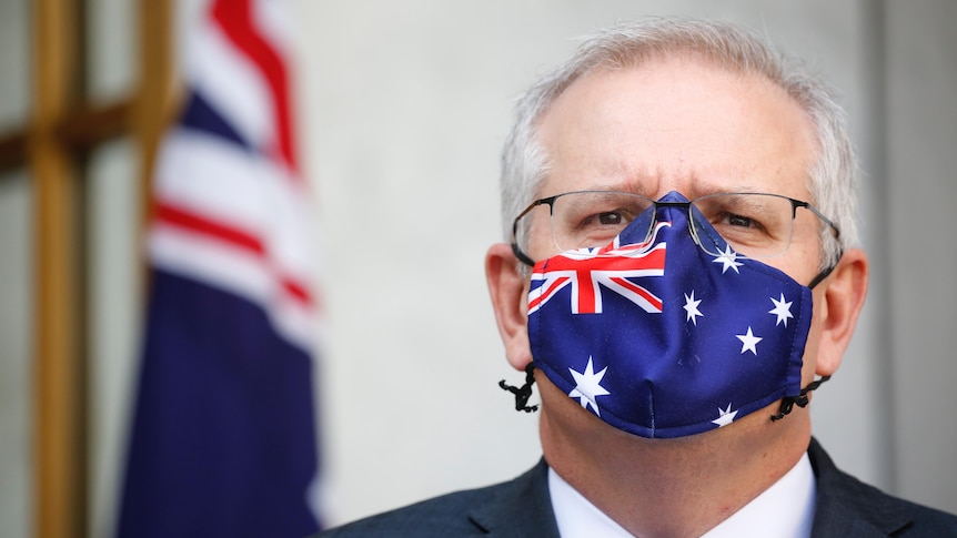 Tight shot of Morrison is staring straight ahead wearing a mask with the Australian flag on it.