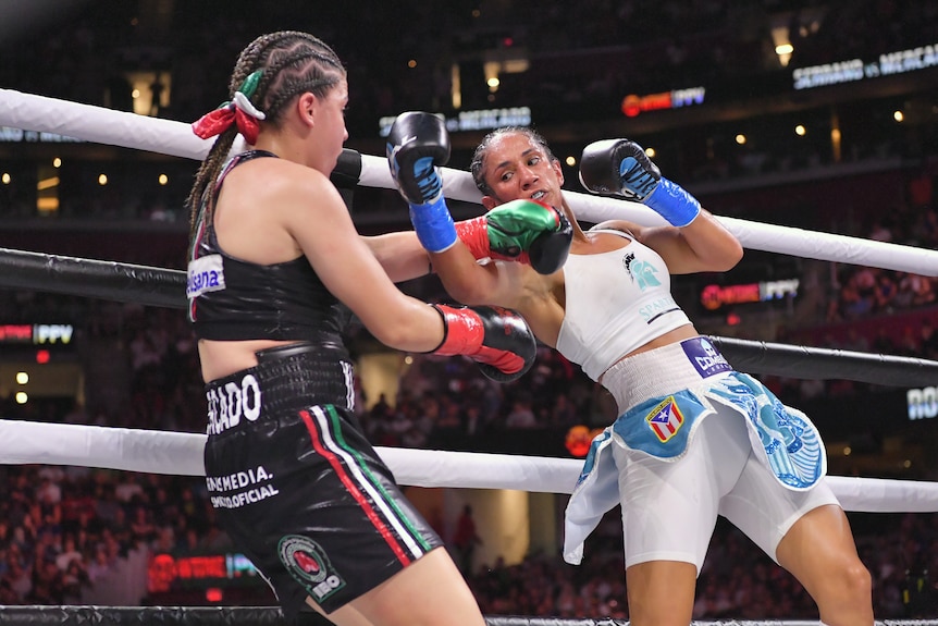 Amanda Serrano leans back and punches at Yamileth Marcado