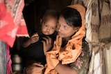 Rohingya mother Bitani* stands in her makeshift tent in Cox's Bazar, Bangladesh with her 18 month-old daughter.