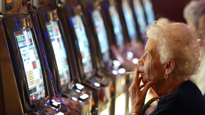 A woman plays a poker machine