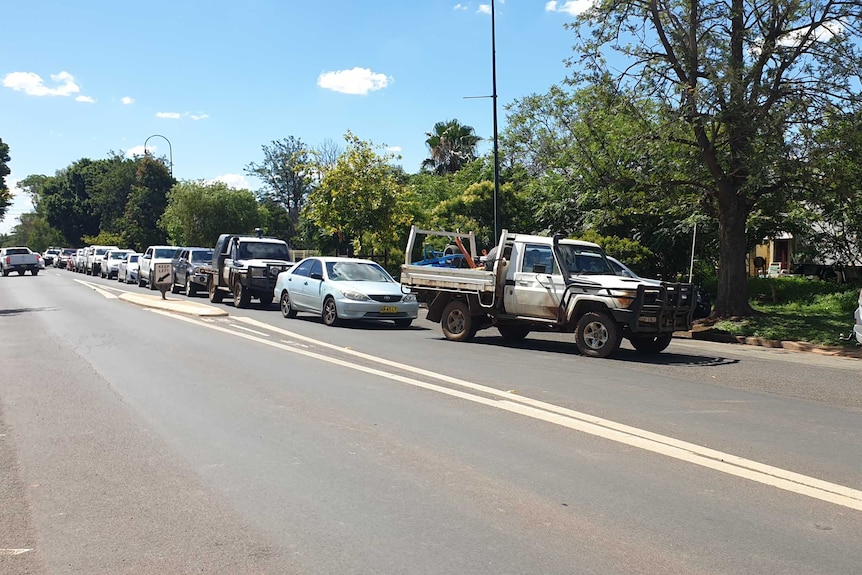 A line of cars waits on the side of the road