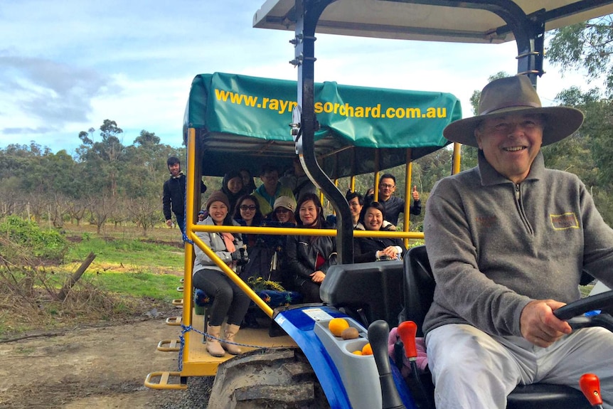 Len Rayner with a group of tourists from Singaore