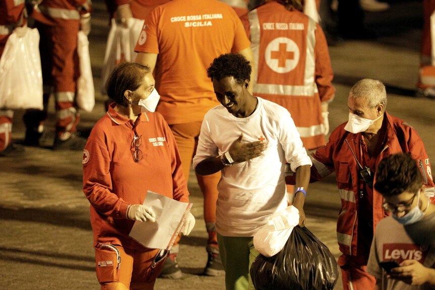 A migrant is helped by Red Cross members.