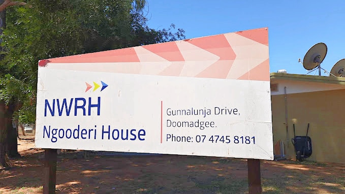 A large sign out the front of a building reading NWRH Ngooderi House