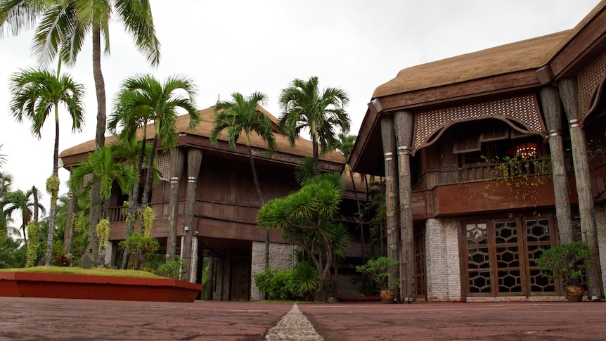 From a low angle, you look up at a grand Filipino mansion made out of coconuts and breezeblocks.