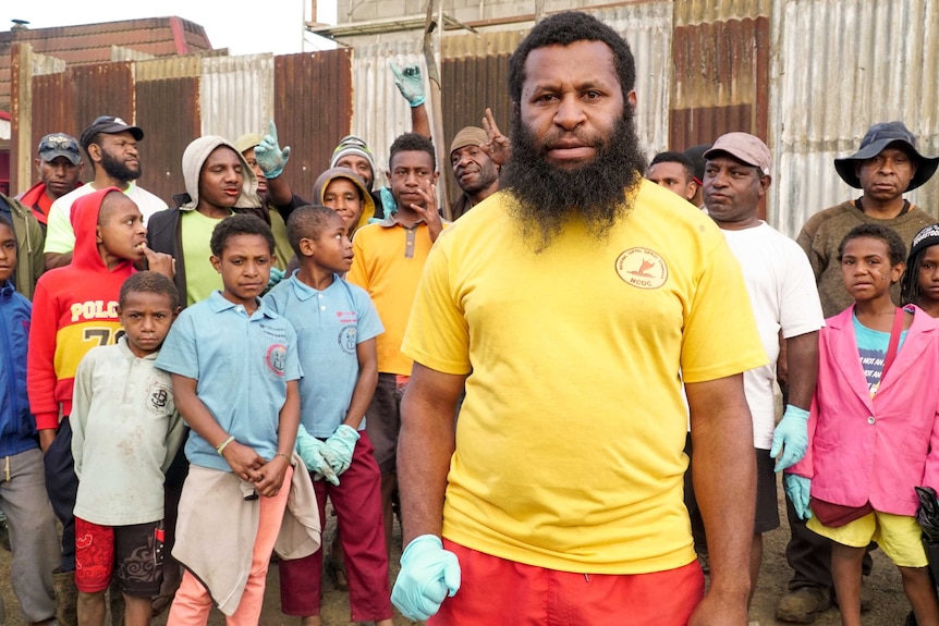 Brian poses for a photo with a group of Mount Hagen locals behind him.