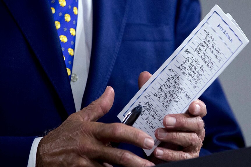 A close up shot of a notepad in Joe Biden's hands with notes about Kamala Harris written on it