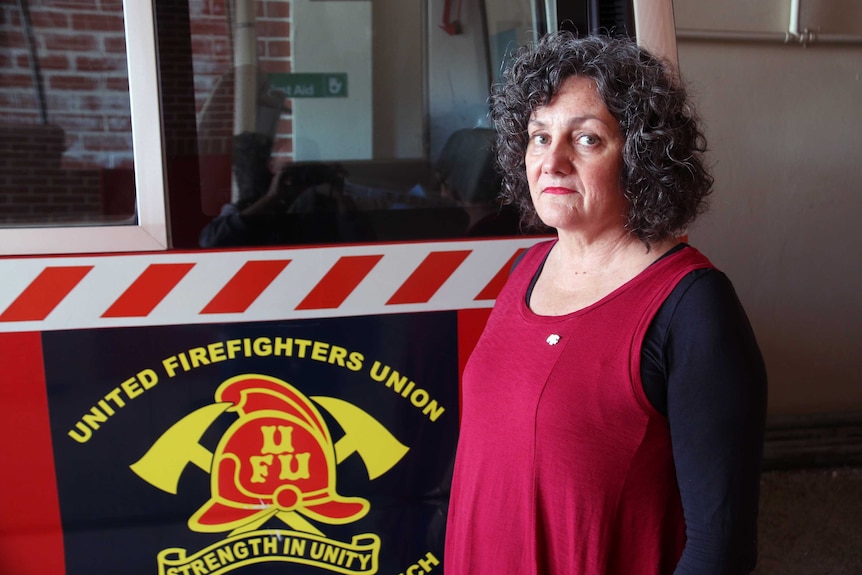 Lea stands in front of a fire truck.