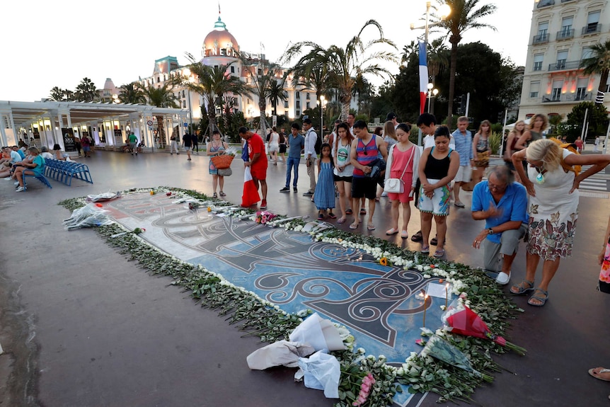 People look at a memorial on the Promenade des Anglais in Nice.
