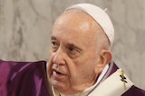 The pope dressed in purple puts ashes on a man's forehead