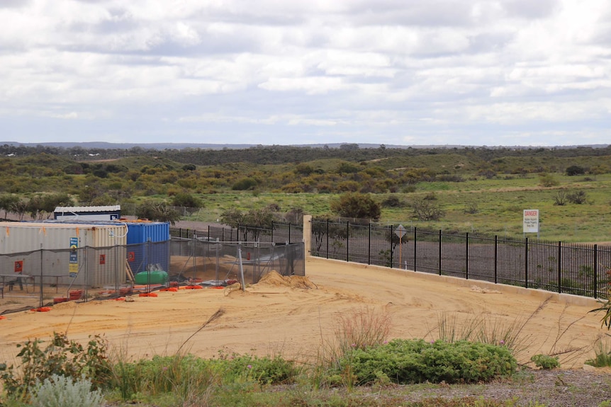 Some fences and two shipping containers sit on an otherwise vacant area of land at Alkimos.