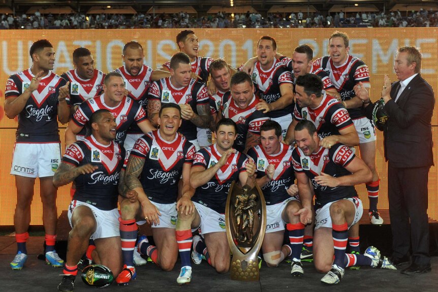 The Sydney Roosters pose with the Provan-Summons premiership trophy after winning the 2013 NRL grand final.