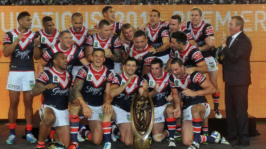 The Sydney Roosters pose with the Provan-Summons premiership trophy after winning the 2013 NRL grand final.