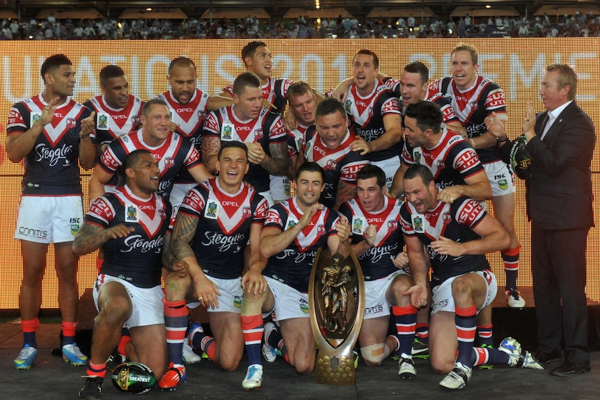 The Sydney Roosters pose with the Provan-Summons premiership trophy after winning the 2013 NRL grand final.