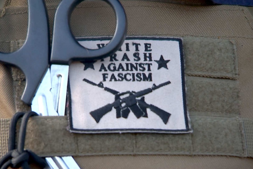 A patch saying "white trash against facism", attached to Redneck Revolt gear.