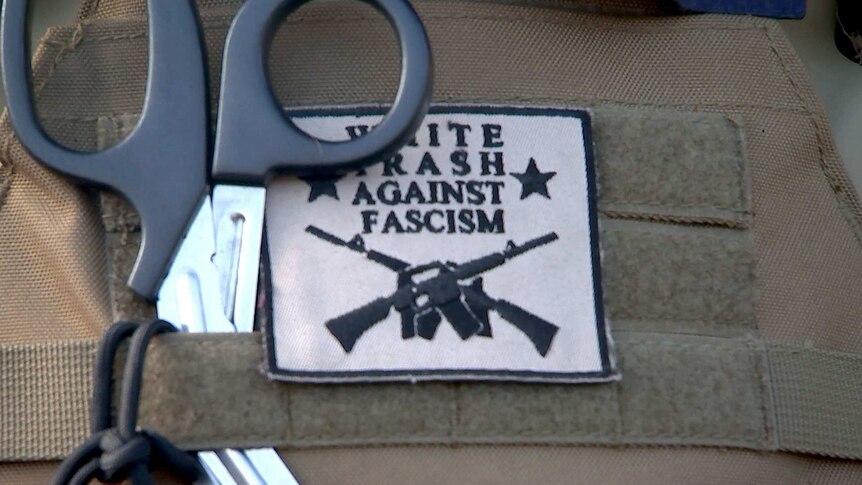 A patch saying "white trash against facism", attached to Redneck Revolt gear.