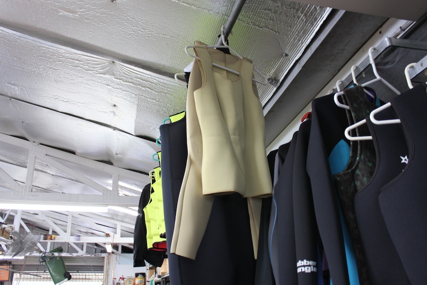 Nude colored wet suits hanging on rack