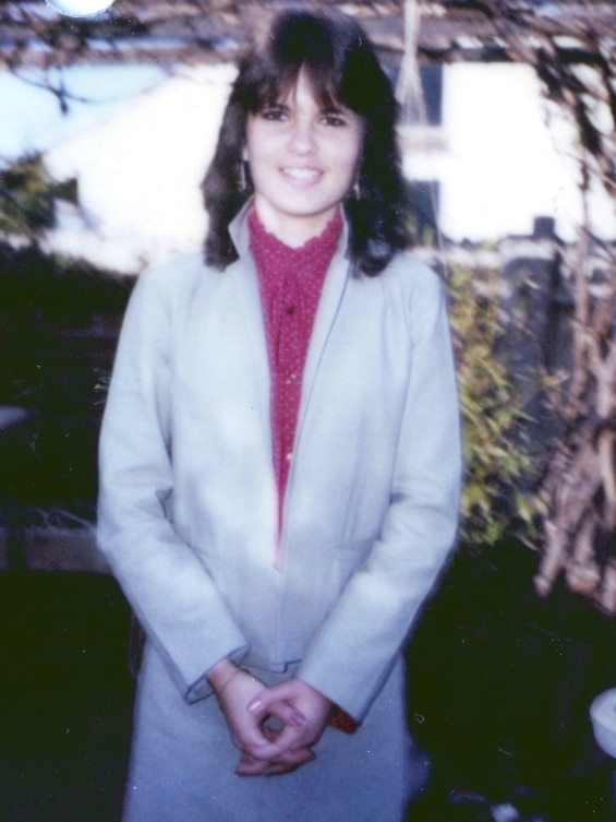 Megan Louise Mulquiney standing in a white jacket and skirt and a pink shirt.