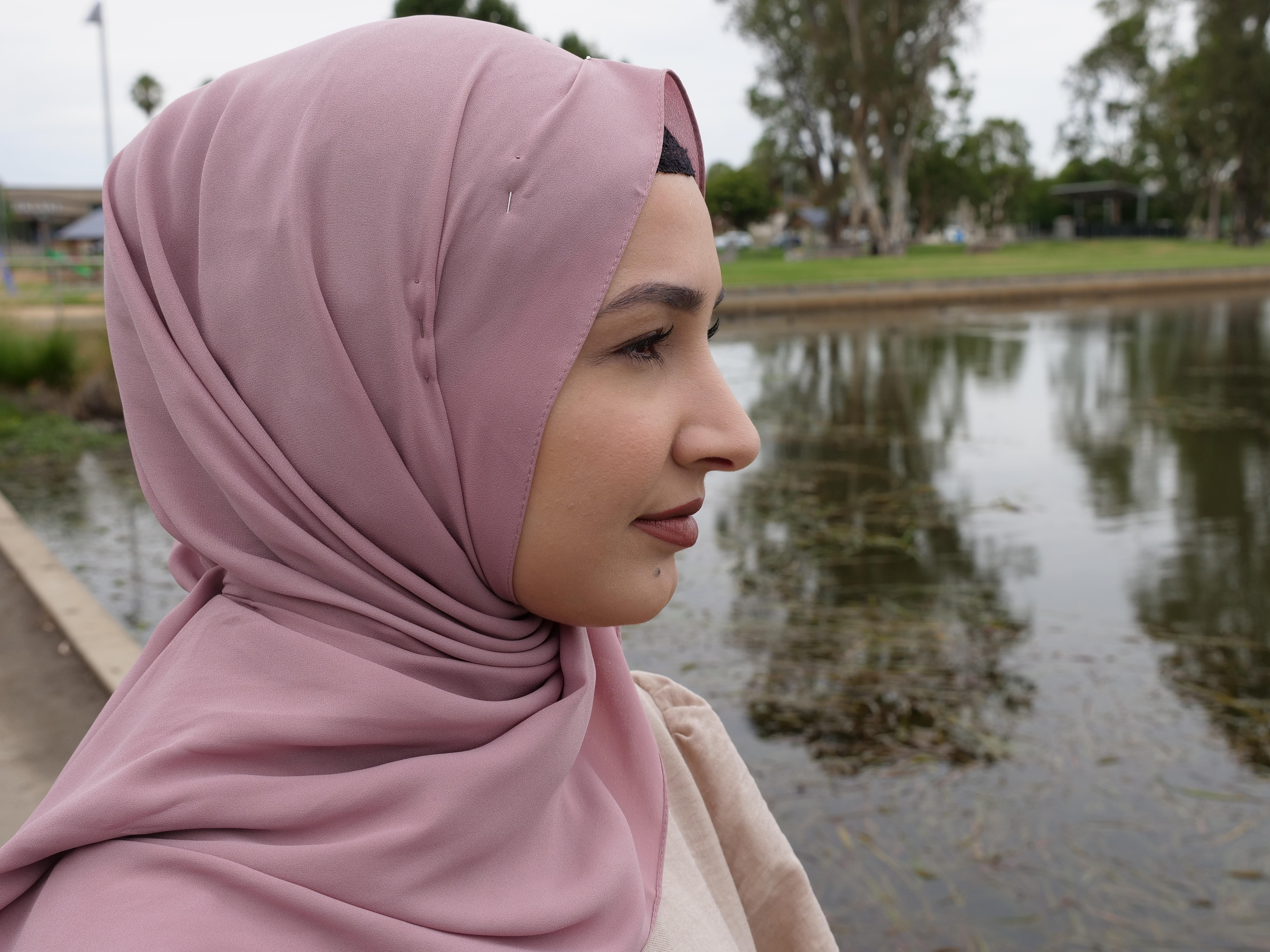A close up photo of a woman staring out across a lake 