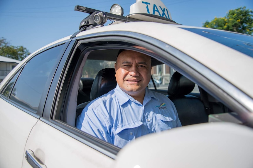 Brian Tauafao sits in the driver's seat of his taxi.