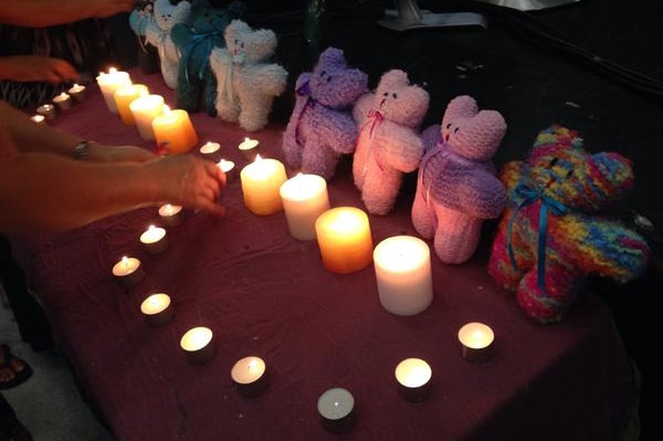 People pay their respects at a memorial service for eight children killed in Cairns, December 21 2014