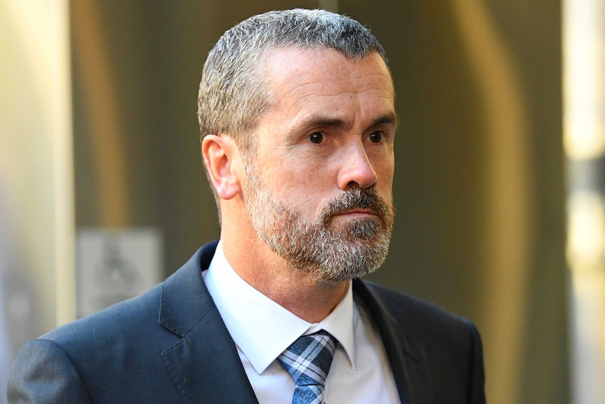 Ross Fowler, a man with short black-and-grey hair and a beard in a suit outside court.