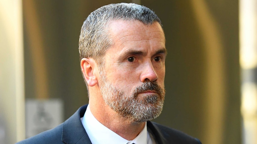 Ross Fowler, a man with short black-and-grey hair and a beard in a suit outside court.