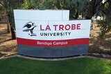 A sign on a green lawn reads 'La Trobe University Bendigo Campus'.