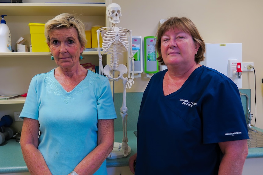 Gabi Plumm and Julie McKay stand in a room in the Cardwell GP clinic, medical instruments are in the cabinet behind them.