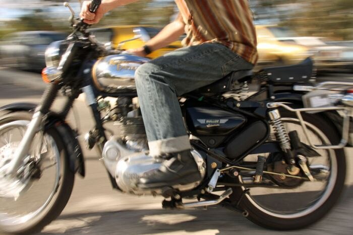 seorang pengendara motor menggunakan alat pelindung diri yang layak