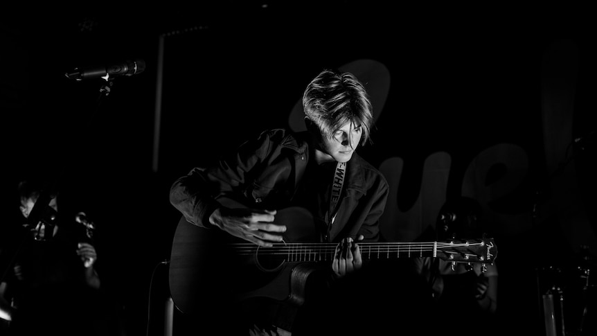 Black and white image of Ruel with acoustic guitar