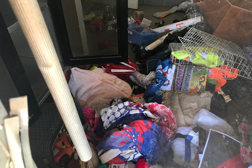 Blankets, toys and other items strewn all over the floor of a room trashed by offenders. 