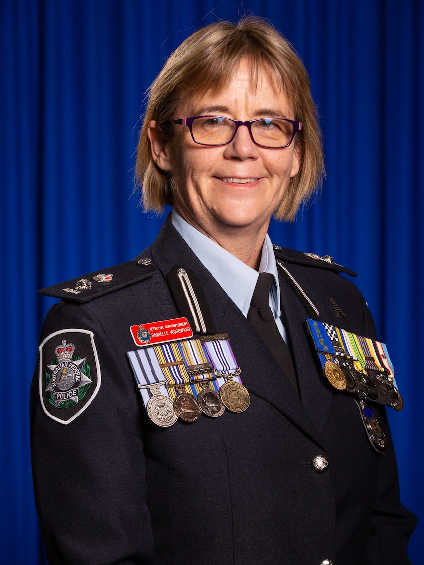 Danielle Woodward smiling wearing a number of police medals on her jacket. 