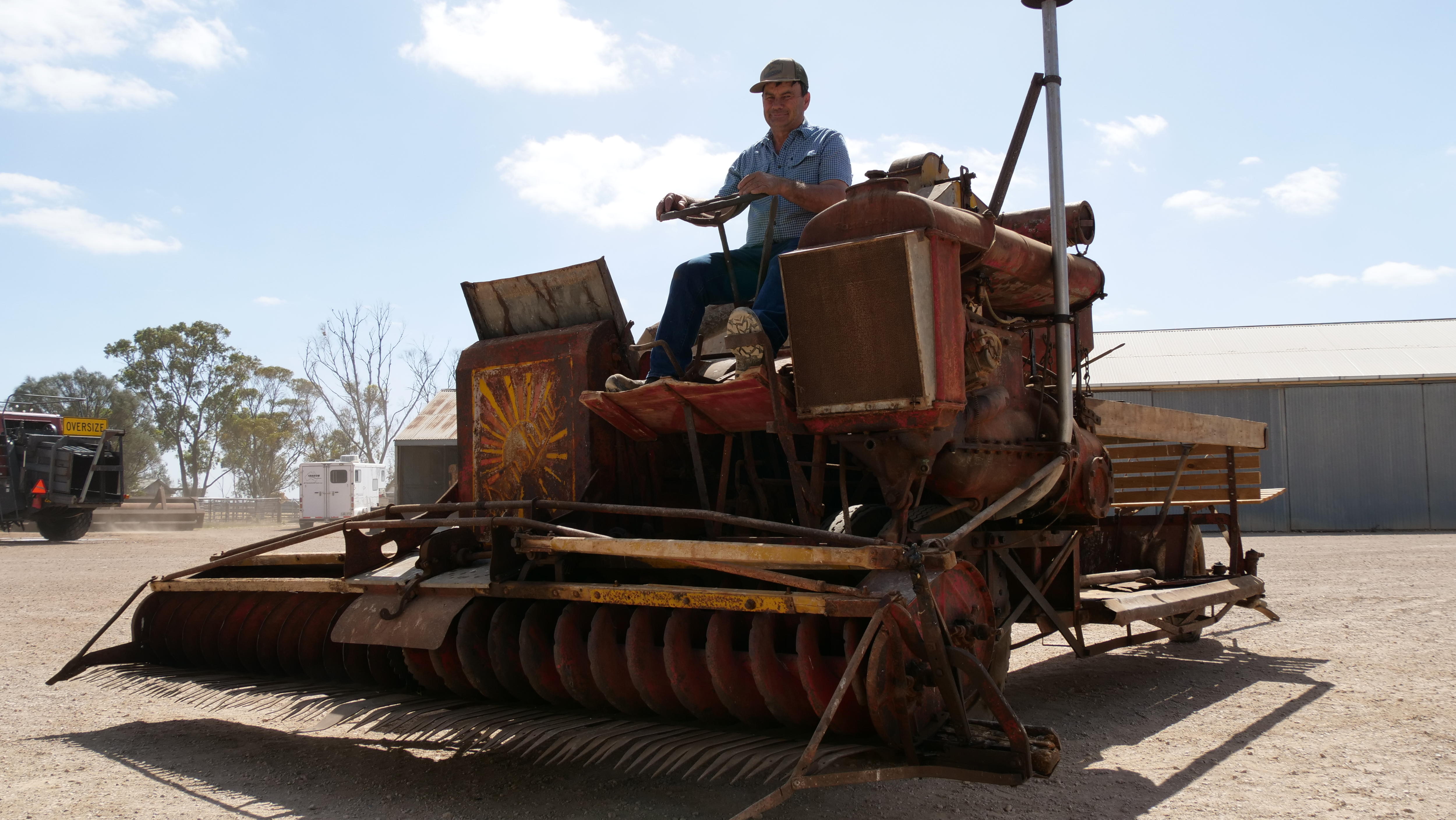 Um homem sentado em uma colheitadeira de 95 anos. 