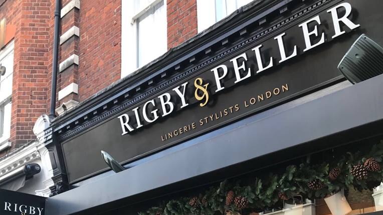 The Rigby & Peller shopfront painted black and decorated with greenery and mannequins in lingerie