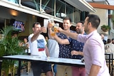 Drinkers celebrating at an outdoor table at a pub