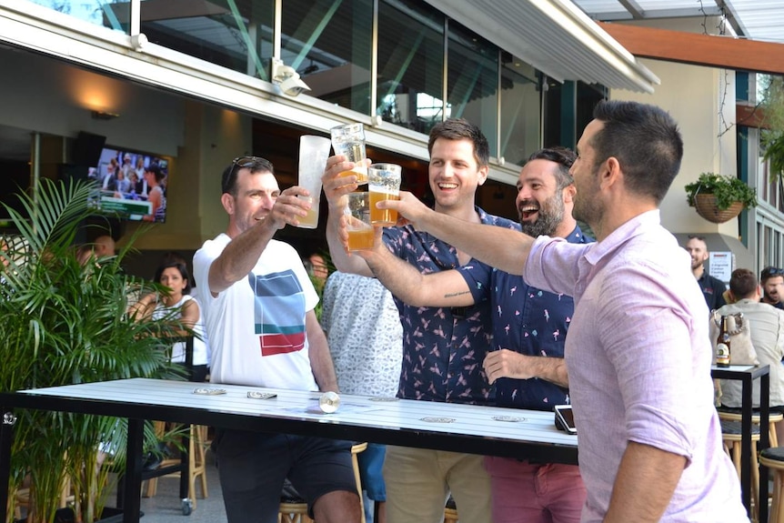 Drinkers celebrating at an outdoor table at a pub