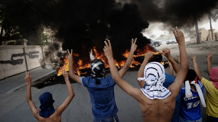 Bahraini protesters flash victory signs