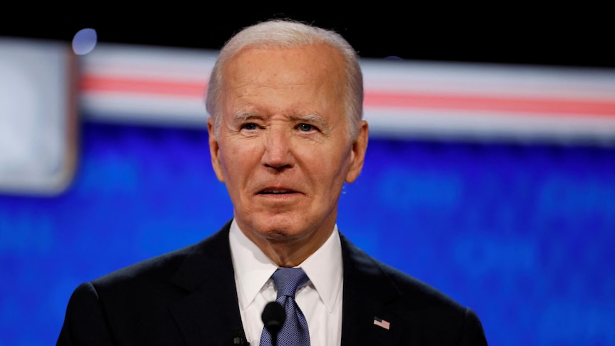 Biden wearing a suit looking off to the distance with his mouth a little open