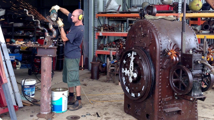 Scupltor Christopher Trotter works on his Blumbergville Clock.