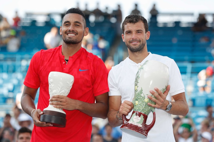 Nick Kyrgios with the runner up's trophy and Grigor Dimitrov with the winner's trophy.
