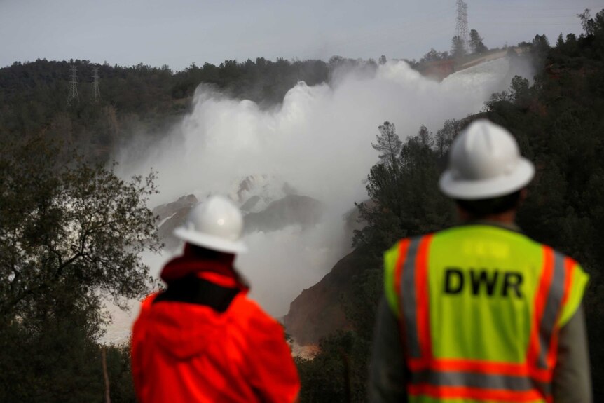 Workers look on at Oroville Dam spillway
